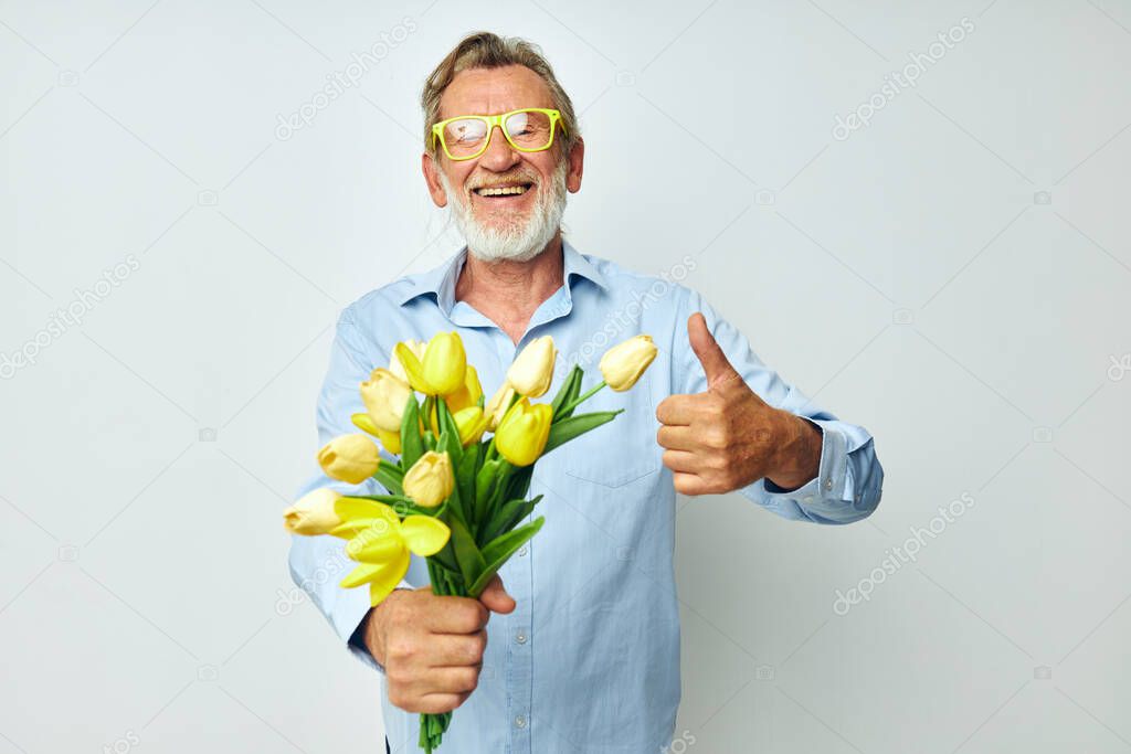 Portrait of happy senior man a bouquet of flowers with glasses as a gift unaltered