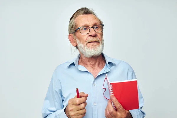 Portrét starší muž zapisuje emoce do zápisníku světlé pozadí — Stock fotografie