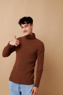 portrait of a young man posing in brown sweater self confidence fashion isolated background unaltered clipart