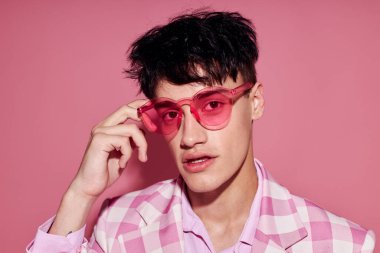 Genç bir adam pembe gömlek ve gözlüklü ceket şık bir moda izole edilmiş arka plan değiştirilmemiş