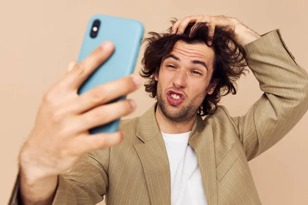 Homem alegre em um terno posando emoções olhando para o telefone isolado fundo — Fotografia de Stock