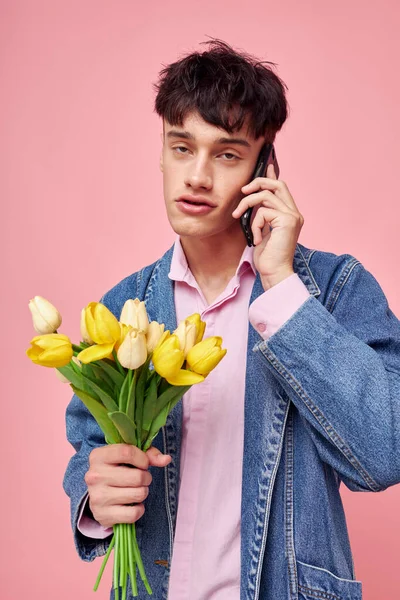 Молодой парень с букетом цветов разговаривает по телефону подарок свидание — стоковое фото