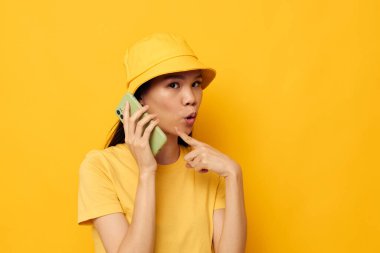 Çekici genç Asyalı kadın elinde bir telefonla yaşam tarzı teknolojisi modelini değiştiriyor.