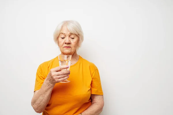 Foto de anciana jubilada sosteniendo un vaso de agua salud emociones de primer plano — Foto de Stock