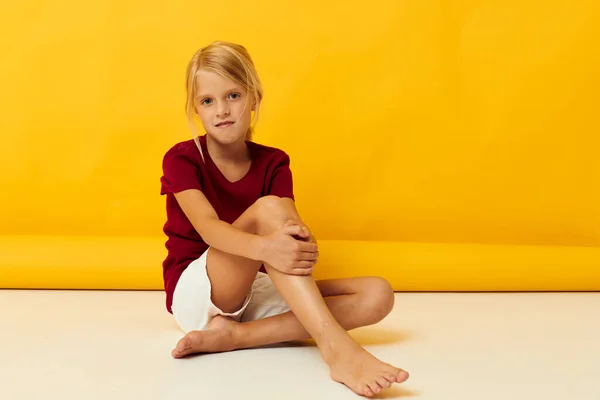 Mała dziewczynka siedzi na podłodze pozowanie w casual ubrania — Zdjęcie stockowe