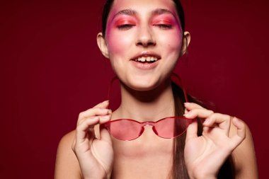 Güzellik moda kadın parlak makyaj moda duyguları poz moda gözlükleri pembe arka plan değiştirilmemiş