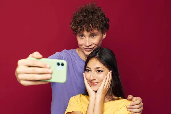 Uomo e donna stile moderno emozioni divertimento telefono rosso sfondo — Foto Stock