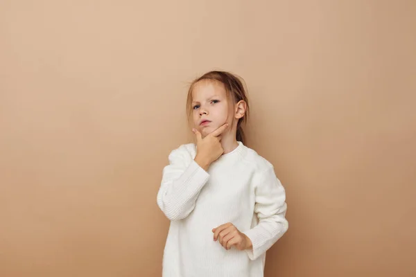 Linda chica en suéter blanco posando gestos de la mano fondo beige — Foto de Stock