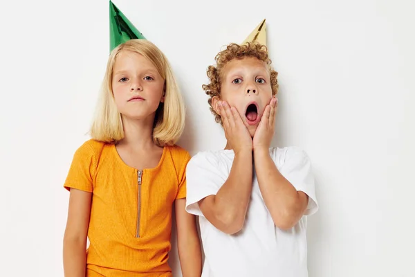 Leuke stijlvolle kinderen in veelkleurige caps verjaardag vakantie emotie geïsoleerde achtergrond ongewijzigd — Stockfoto