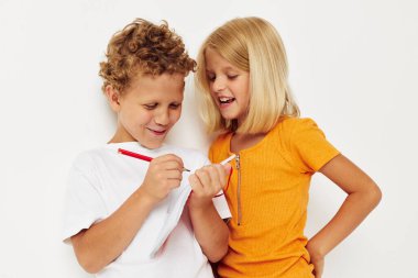 Neşeli çocuklar not defterinin yanında durur duygularını çizer renk arkaplanı değişmez