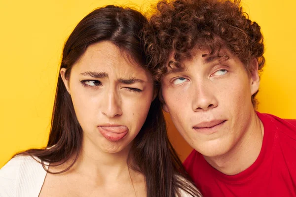 Jeune garçon et fille ensemble posant émotions close-up fond jaune inchangé — Photo
