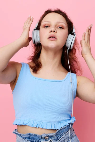 Lány visel fejhallgató tánc mozgás szórakozás rózsaszín háttér változatlan — Stock Fotó