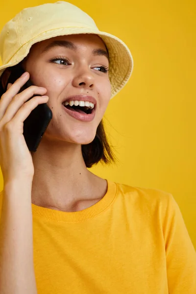 Όμορφη κοπέλα σε ένα κίτρινο καπέλο Νεανικό στυλ casual μιλώντας στο τηλέφωνο απομονωμένο φόντο — Φωτογραφία Αρχείου