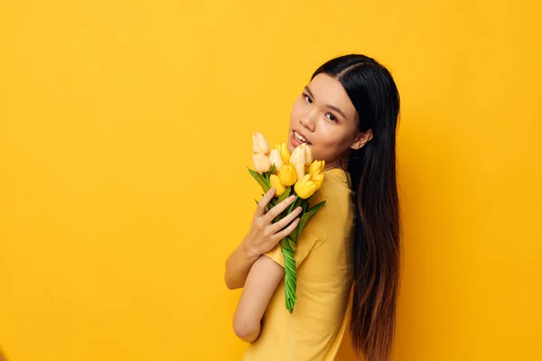 Kvinna med asiatiskt utseende bukett med blommor i händerna våren kul poserar studio modell oförändrad — Stockfoto