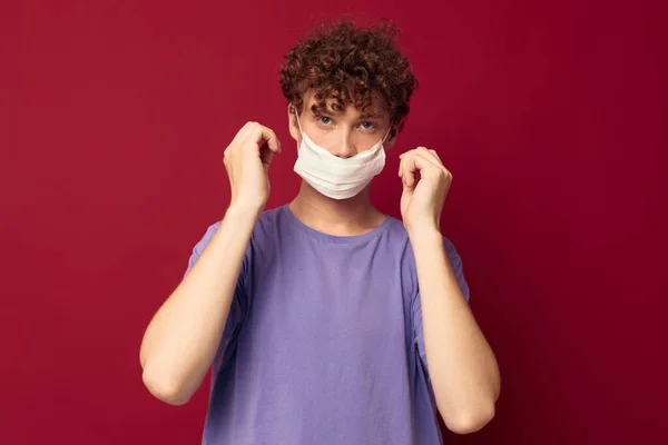 Un giovane uomo capelli rossi maschera protettiva protezione contro la malattia isolato sfondo inalterato — Foto Stock