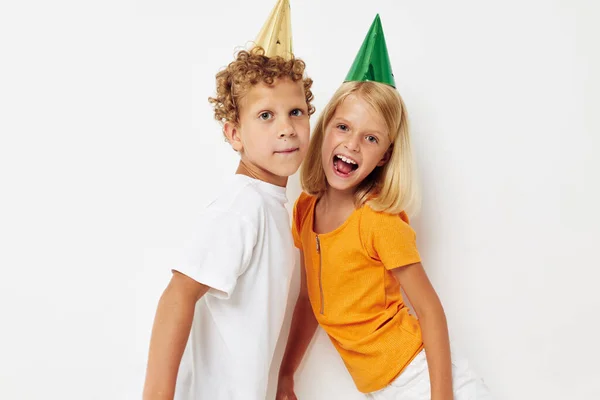 Niños alegres posando emociones vacaciones coloridas gorras aislado fondo inalterado — Foto de Stock
