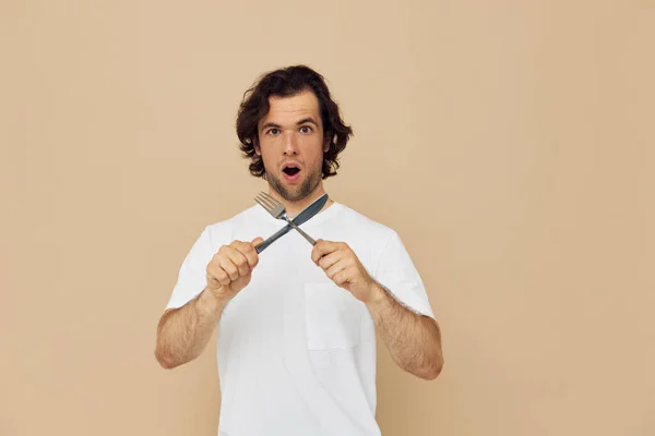 Veselý muž v bílém tričku s nožem a vidličkou Životní styl nezměněn — Stock fotografie