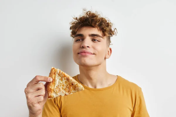 ハンサムな若い男食べるピザポーズクローズアップライフスタイル変更なし — ストック写真