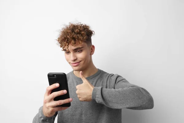 Красивий молодий чоловік з телефоном в руці спілкування ізольований фон — стокове фото