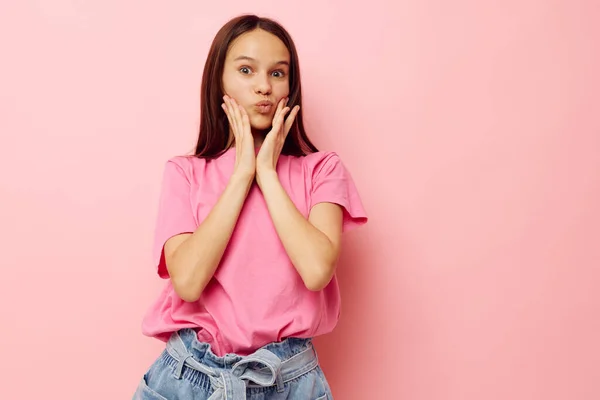 Jeune belle femme dans un t-shirt rose vêtements décontractés fond rose — Photo