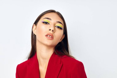 Kırmızı ceketli güzel esmer. Kozmetik gülümsemeli. Stüdyo modeli değişmemiş.