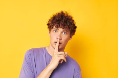 Kırmızı saçlı, kıvırcık saçlı, mor tişörtlü adam duygularına hakim oluyor.