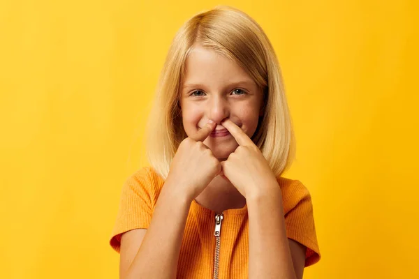 Schattig klein meisje met blond haar poseren gele achtergrond — Stockfoto