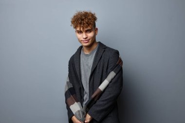 Ceketli çekici bir adam. Kareli bir eşarp. Gri bir geçmişi var.