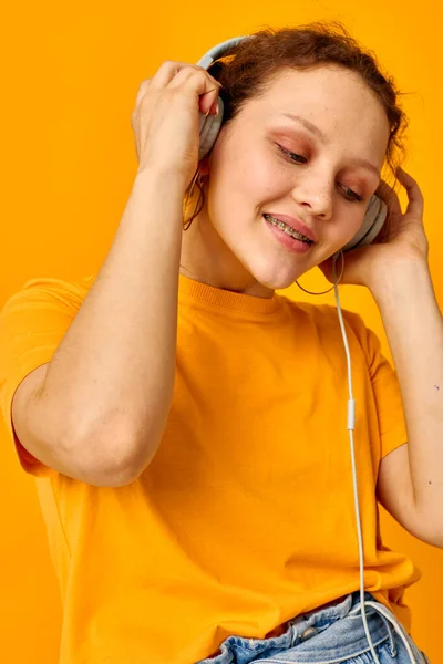 Mujer alegre escuchando música en auriculares Estilo juvenil fondos aislados inalterados — Foto de Stock