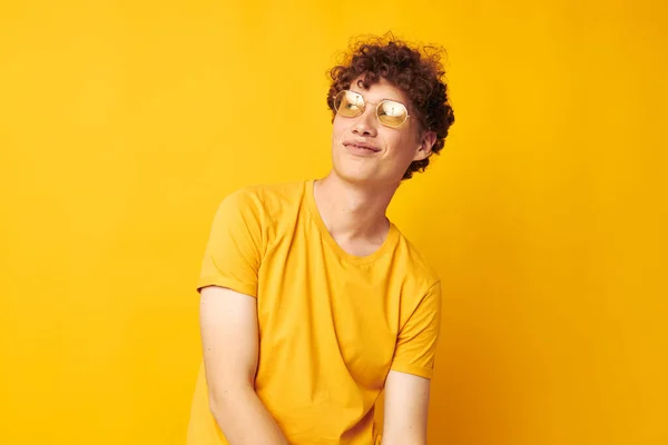Tipo con pelo rizado rojo usando gafas con estilo camiseta amarilla posando estilo de vida inalterado — Foto de Stock