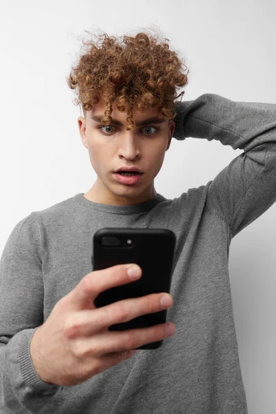 Homem atraente olhando para o telefone moda isolado fundo — Fotografia de Stock