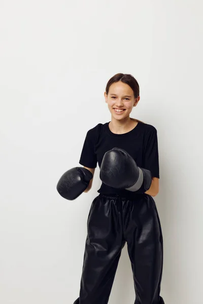 若い女性のボクシンググローブで黒パンツとTシャツの隔離された背景 — ストック写真