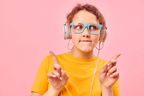 Schöne Frau gelb T-Shirt Kopfhörer Unterhaltung Musik Spaß rosa Hintergrund unverändert — Stockfoto