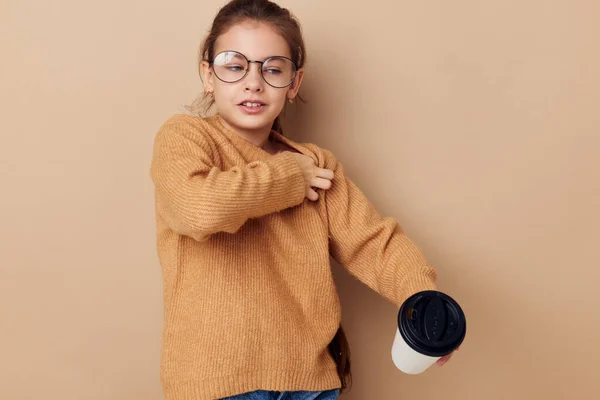 Petite fille portant des lunettes posant verre avec boisson — Photo