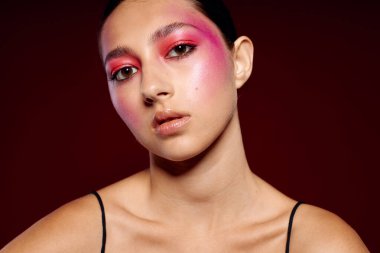 Genç, güzel bir kadın lüks kozmetik ürünleri sergileyen el kol hareketleri yapıyor. Geçmişi değiştirilmemiş.