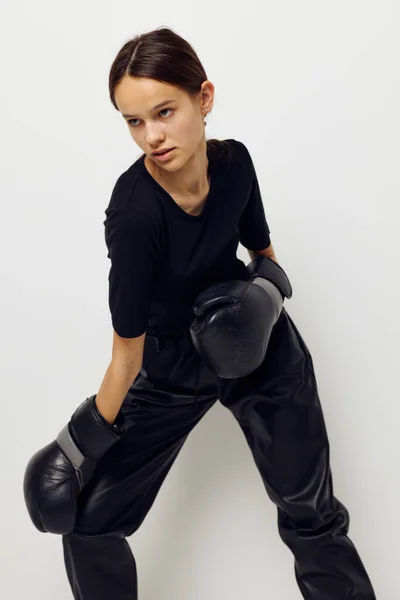 Jovem mulher em preto esportes uniforme luvas de boxe posando Estilo de vida inalterado — Fotografia de Stock