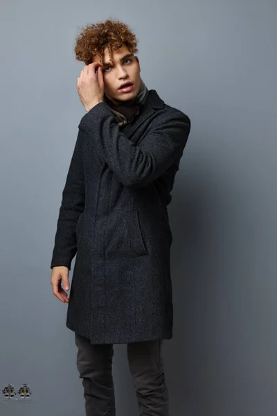 Pohledný mladý muž elegantní styl sebevědomí móda šedé pozadí — Stock fotografie