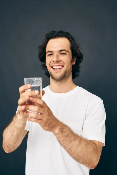 Mann Glas Wasser in seinen Händen Emotionen posiert beige Hintergrund — Stockfoto