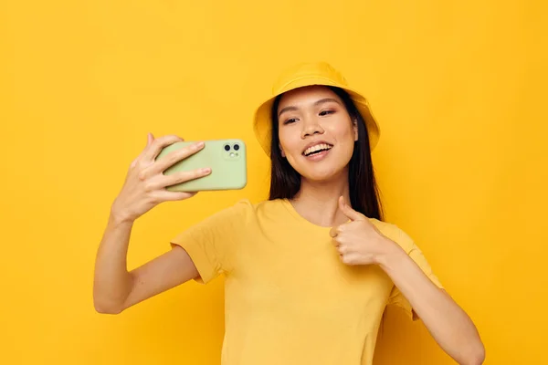 Donna in possesso di un telefono posa stile di vita tecnologia giallo sfondo inalterato — Foto Stock