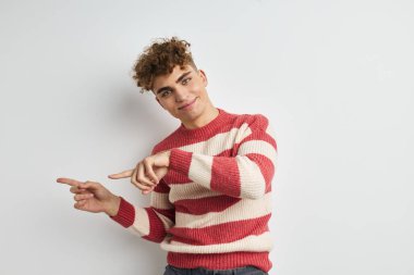 Çizgili kazaklı yakışıklı adam yaşam tarzını değiştirmeden poz veriyor.