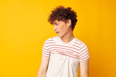 Beyaz tişörtlü genç bir kıvırcık adamın portresi çizgili bir gençlik tarzı barındırıyor.