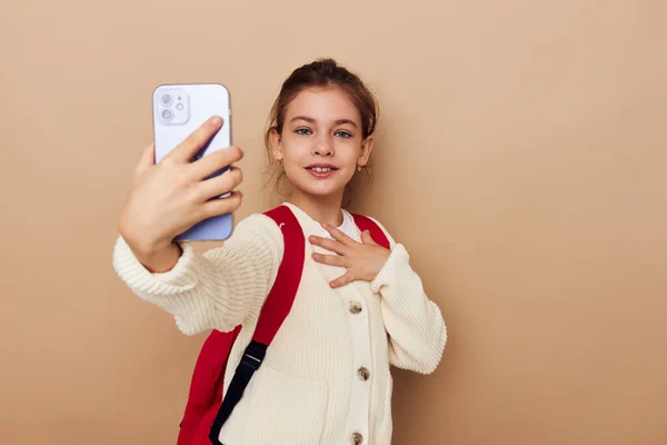 Carino ragazza studentessa zaino telefono in mano isolato sfondo — Foto Stock