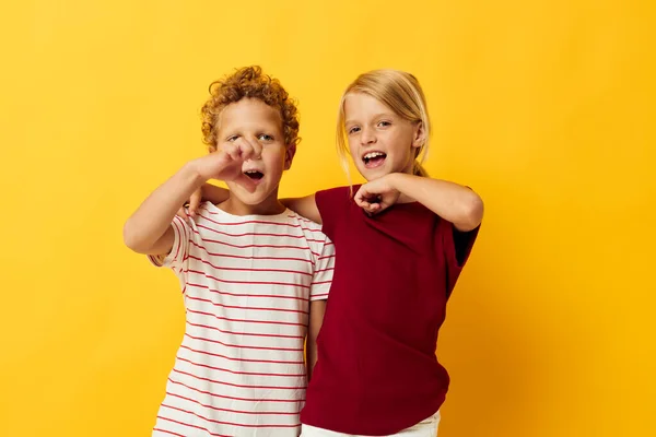 Cute stylish kids standing side by side posing childhood emotions yellow background — Stock fotografie