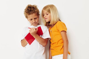 Renkli tişörtlerle gezen sevimli anaokulu çocukları. Not defteri rengi değiştirilmemiş.