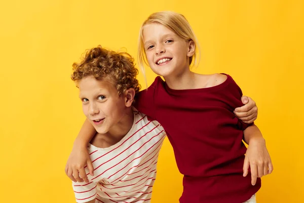 Милые стильные дети стоят бок о бок, создавая детские эмоции, желтый фон — стоковое фото