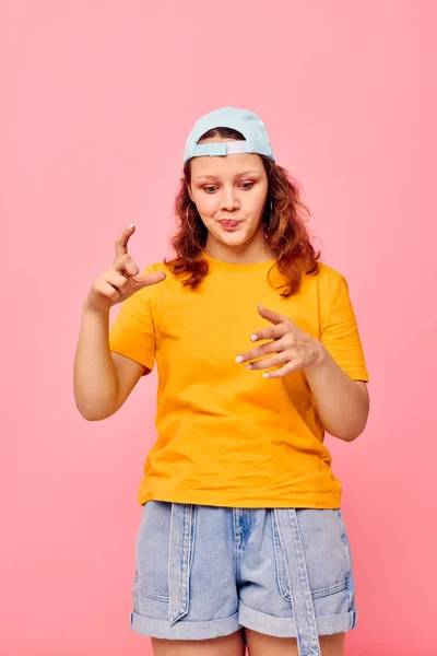 Grappig meisje in een geel t-shirt en blauwe pet poseren emoties Lifestyle ongewijzigd — Stockfoto