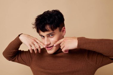 Kahverengi süveter giyen yakışıklı adam kendine güvenen moda, değiştirilmemiş arka plan.