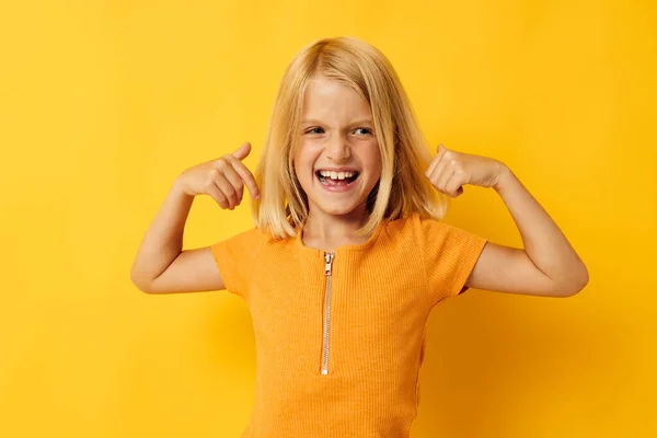Dítě dívka ve žlutém tričku úsměv pózovat studio barva pozadí beze změny — Stock fotografie