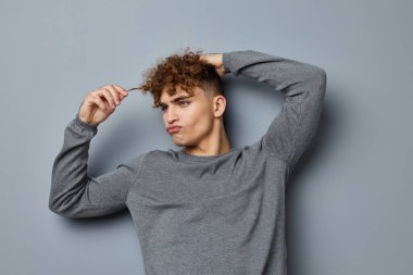 Gri sweatshirt 'lü tuhaf adam. Moda stüdyosu. Yaşam tarzı değişmemiş.