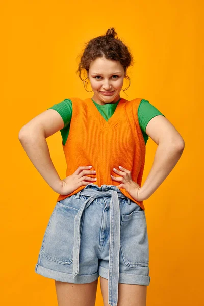 Jovem menina em camisola laranja roupas jovens posando fundo isolado — Fotografia de Stock